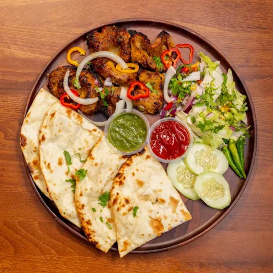 Desi Bistro's Indian platter with grilled chicken, naan, salad, and two dipping sauces.